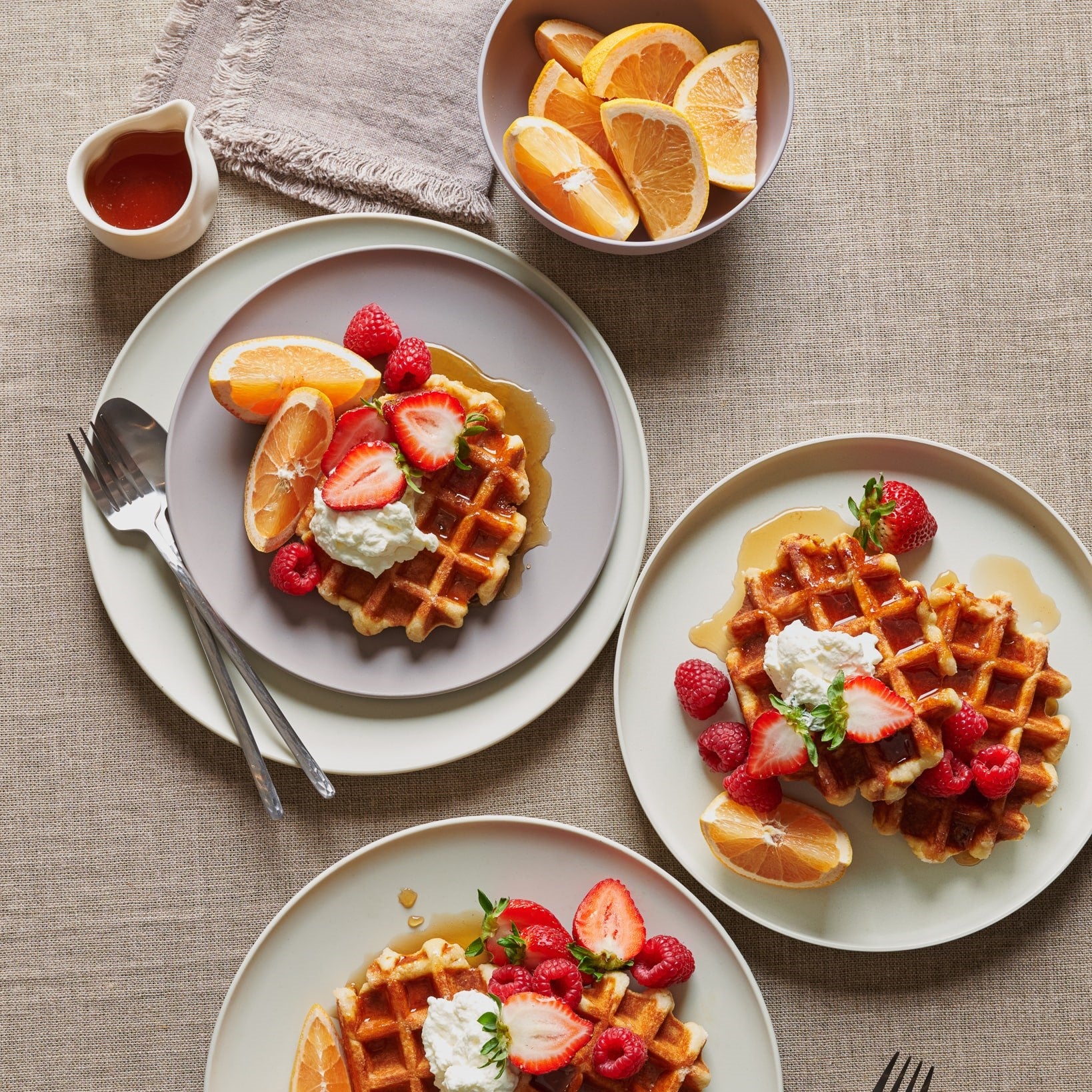 Breakfast waffles and oranges with pastel colored non-toxic plates on a chilly New England autumn morning.